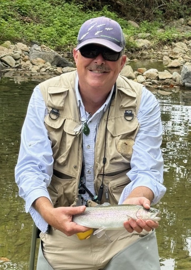 Alan Edmunds holding a trout fish.